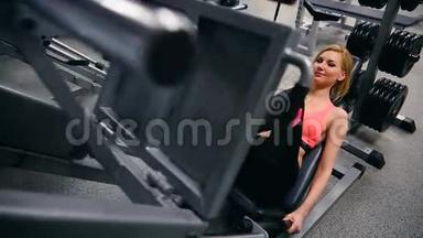 年轻<strong>女子</strong>在健身房的机器出<strong>版</strong>社工作。 在健身房的模拟器里锻炼的西班牙黑人美女